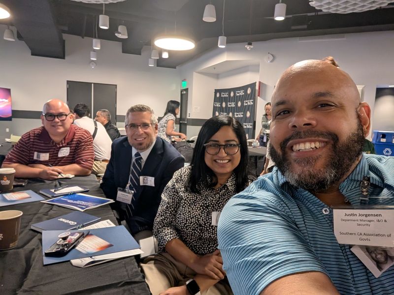 Selfie of Justin Jorgensen with three colleagues at a tabletop session during the Gartner OC AI & Data Summit